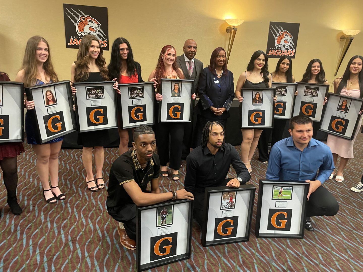 Governors State University President Dr. Cheryl Green and GSU Athletic Director and Head Men's Basketball Coach Tony Bates in the center of some of the 2024 Jaguars' Senior Student-Athletes at the GovState Athletics Sports Banquet April 26.